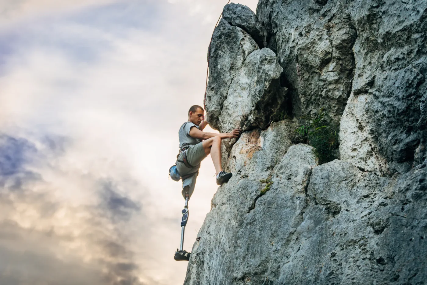 Kletterin mit Beinprothese an einer Felswand